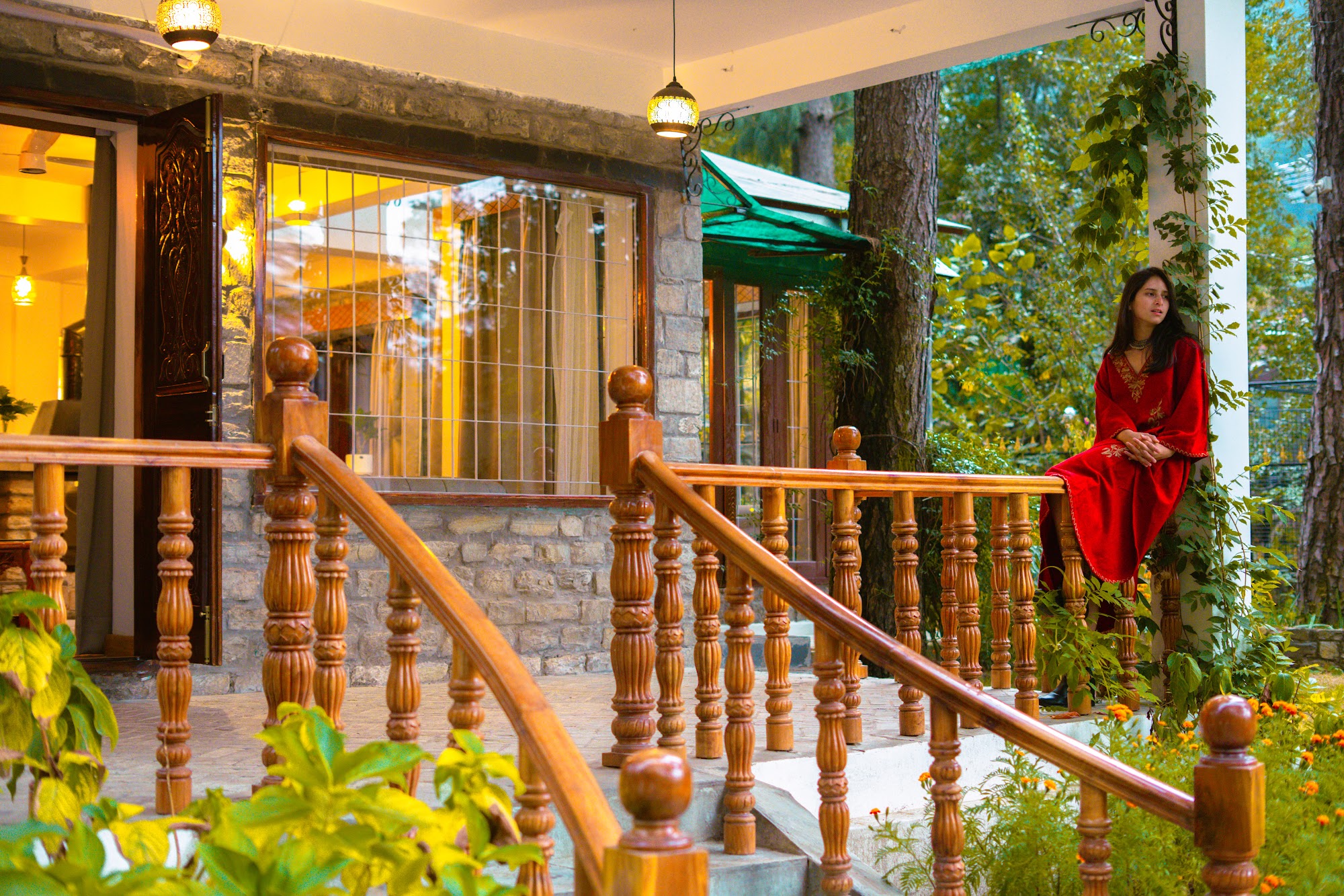 Timber balcony railings and stone walls of River Stone Villa among pine trees